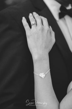 bride groom black tie wedding ring hand on suit with bracelet